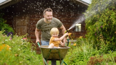 Vader met zoon in de tuin met tuingereedschap – Inboedelverzekering – Particulier
