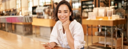 Portrait,Of,Asian,Businesswoman,,Sitting,On,Table,In,Cafe,,Drinking